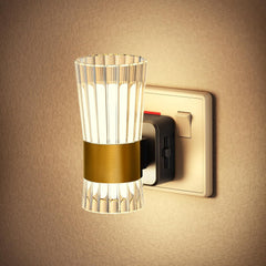 Wall-mounted light fixture with glass shade and gold accent on a beige wall.