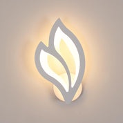 Wall-mounted light fixture with leaf design on a neutral background