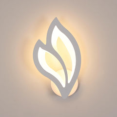 Wall-mounted light fixture with leaf design on a neutral background