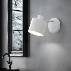 White wall-mounted lamp on a gray wall with a window in the background