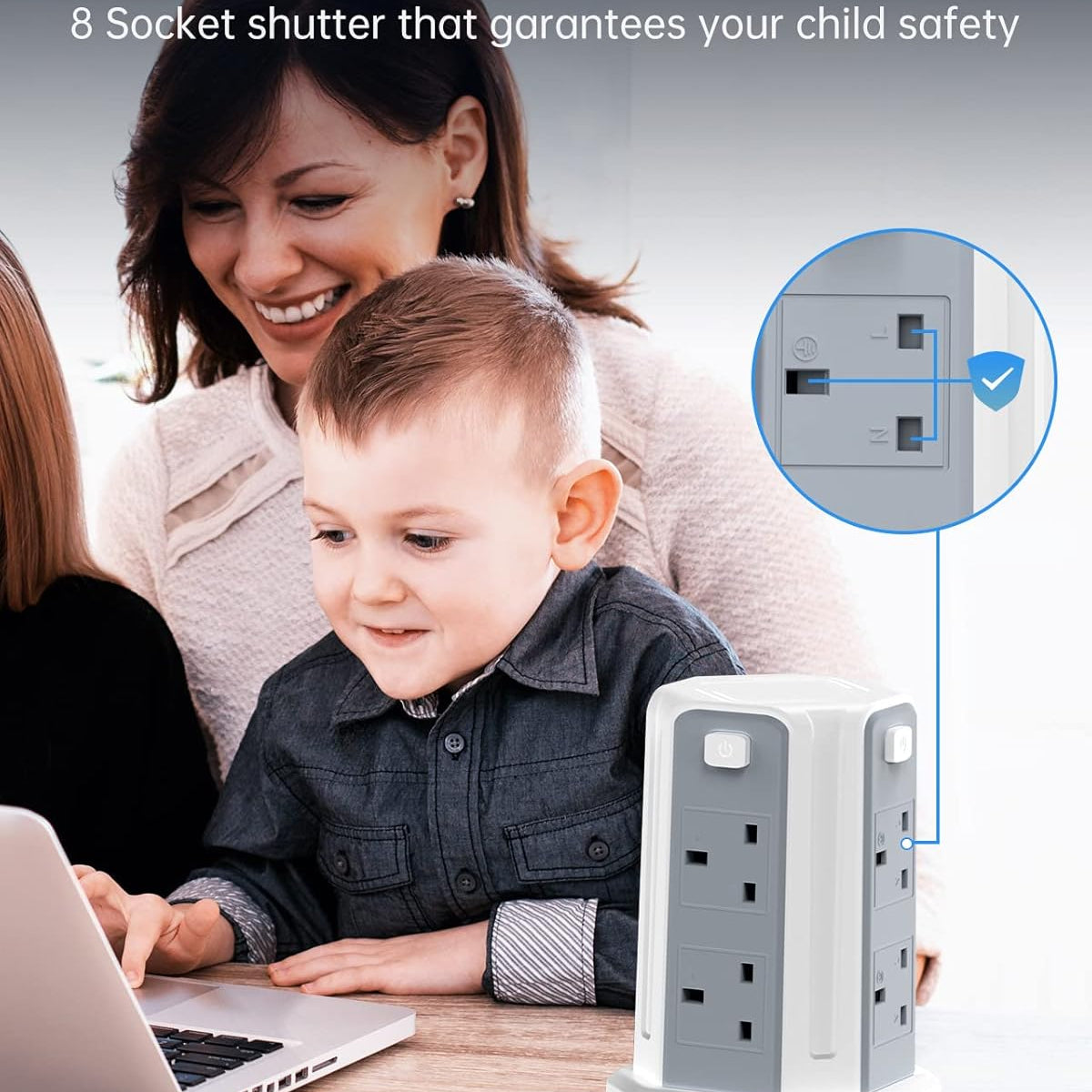 Woman and child using a laptop with a childproofed electrical outlet in the foreground.