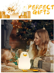 Woman and child with a penguin-shaped night light in front of a Christmas tree.