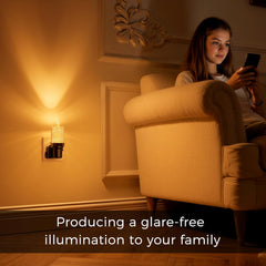 Woman sitting in a cozy armchair using a smartphone in a warmly lit room.