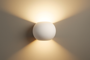 White spherical wall light fixture on a plain wall